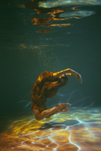 Frau beim Aqua-Yoga im Pool (Unterwasser-Perspektive).