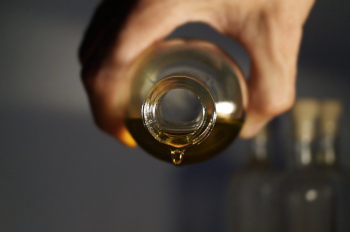 Ätherisches Öl tropft aus Glasflasche.