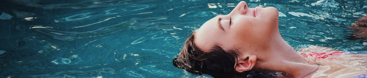 Eine Frau schwimmt in dem mit Algenverhütung behandeltem Wasser