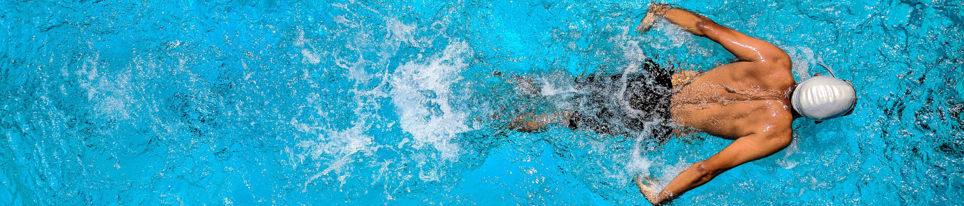 Ein Mann schwimmt im Wasser –Schwimmbäder müssen regelmäßig Chlor kaufen, um zu desinfizieren