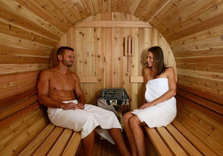 Zwei Personen sitzen in ihrer Sauna mit einem finnischen Saunaofen